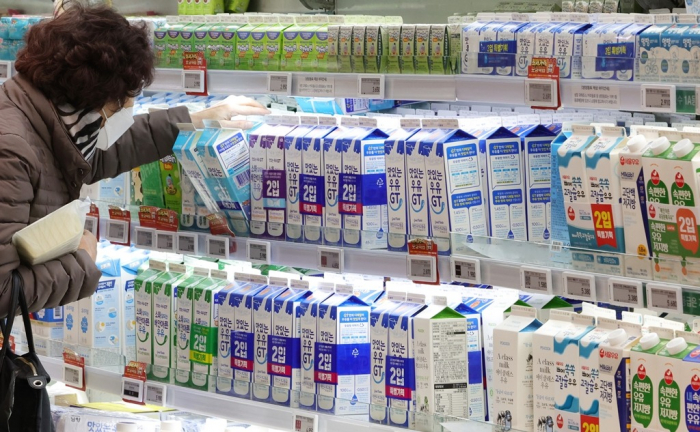 A　customer　picks　up　a　carton　of　milk　at　a　hypermarket　in　Seoul　(File　photo)