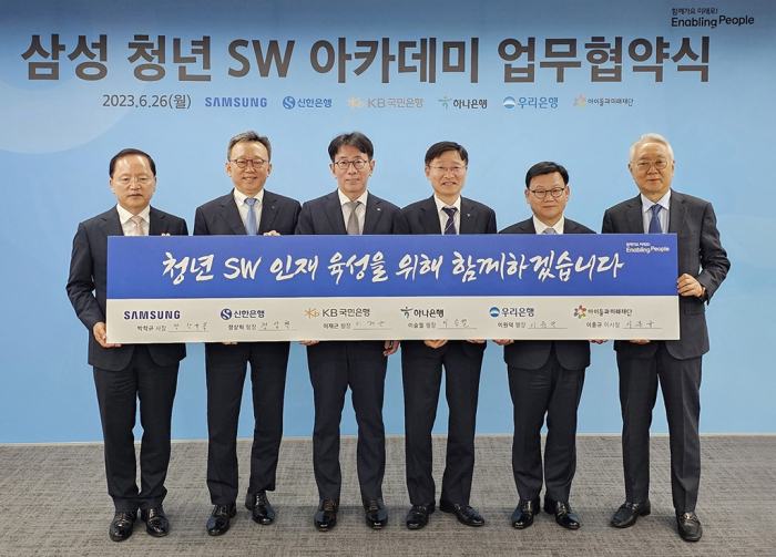 Executives　from　Samsung　and　four　banks　–　Shinhan,　KB　Kookmin,　Hana　and　Woori　–　pose　for　a　photo　after　signing　a　deal　to　foster　fintech　software　engineers　under　the　SSAFY　program