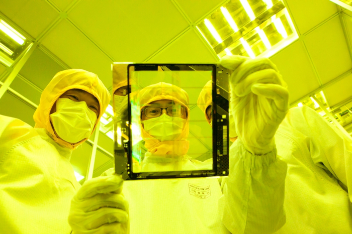 SK　Hynix　researchers　examine　a　chip　device　at　the　company's　cleanroom