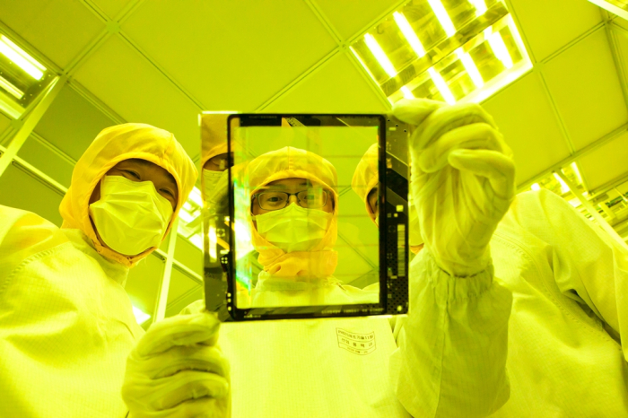 SK Hynix researchers examine a chip device at the company's cleanroom