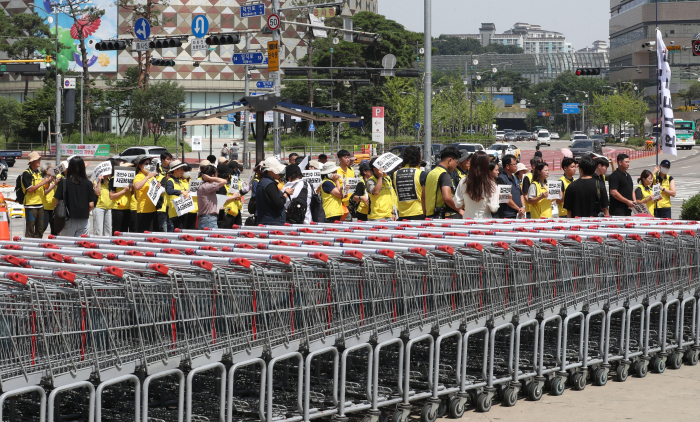 Labor union members protest in front of the Costco outlet in Gwangmyeong