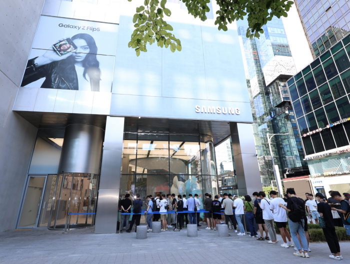 Korean shoppers looking to buy the latest Galaxy Z Fold5 and Flip5 smartphones queue in front of a Samsung sales outlet in Seoul