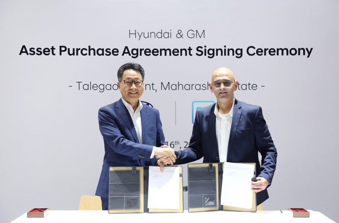 Hyundai　Motor　India　CEO　Kim　Un-soo　(left)　shakes　hands　with　Asifhusen　Khatri,　vice　president　of　GM　India　after　signing　an　asset　purchase　deal