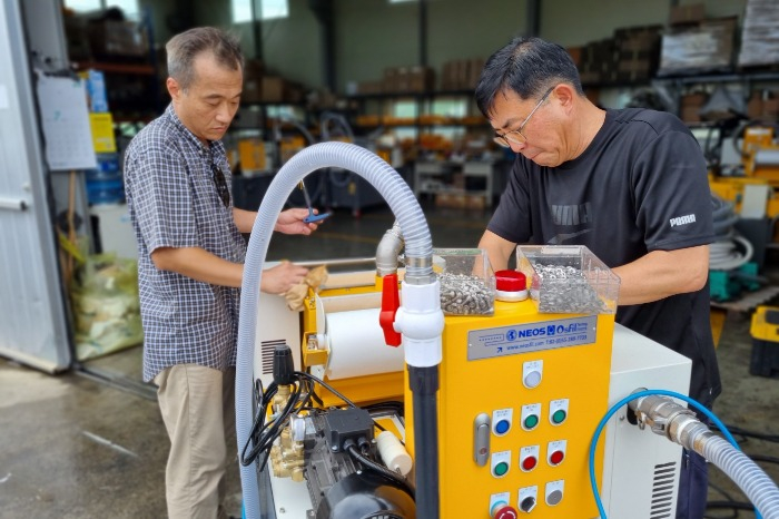 Engineers　of　Neos　inspect　a　coolant　tank　cleaning　machine