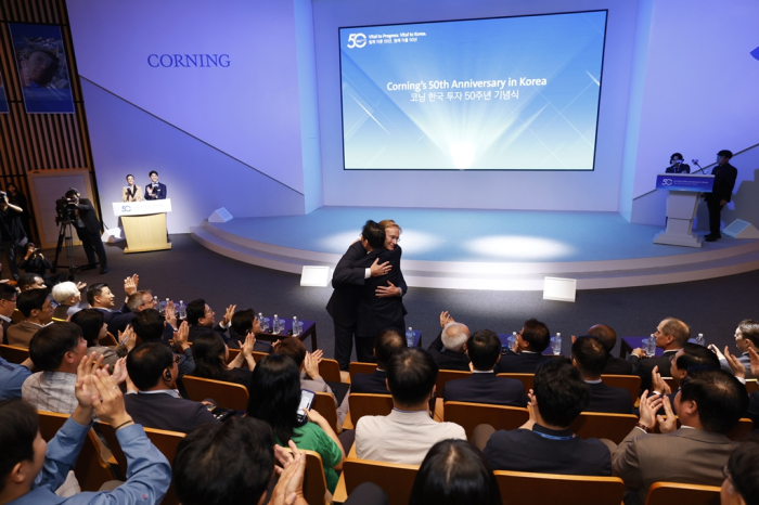 Samsung　Chairman　Jay　Y.　Lee　and　Corning　CEO　Wendell　Weeks　share　a　hug　at　Corning's　50th　anniversary　of　its　Korean　business