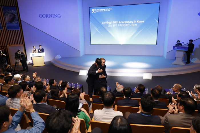 Samsung Chairman Jay Y. Lee and Corning CEO Wendell Weeks share a hug at Corning's 50th anniversary of its Korean business