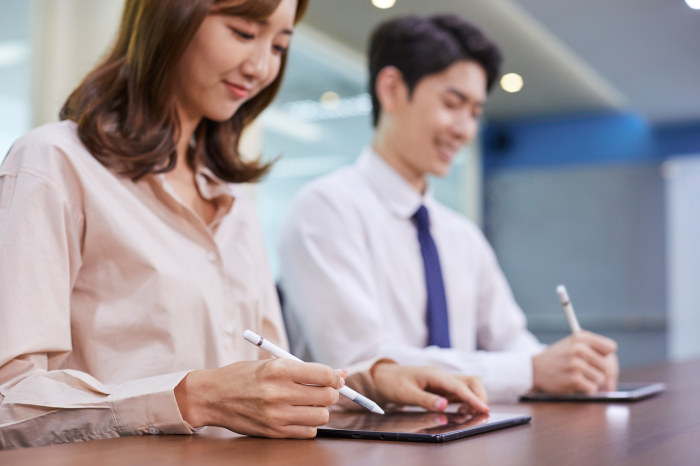 Workers　creating　electronic　signature　systems　for　tablets　(Courtesy　of　Getty　Images)