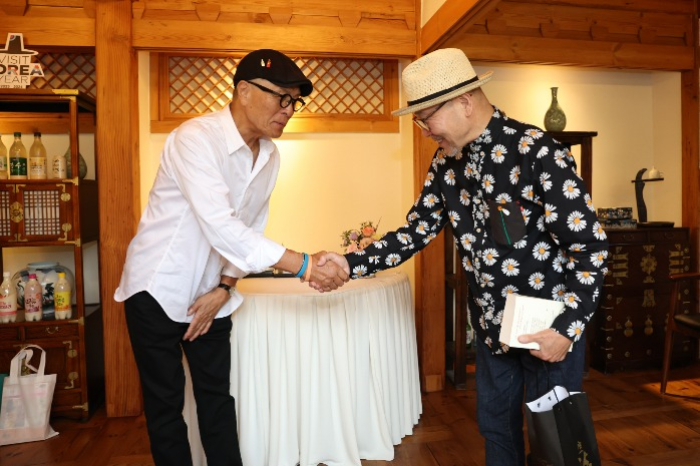 S.Korean cartoon artist Huh Young-man (on left) shakes hands with Japanese writer Masayuki Kusumi in Seoul on Sept. 13, 2023