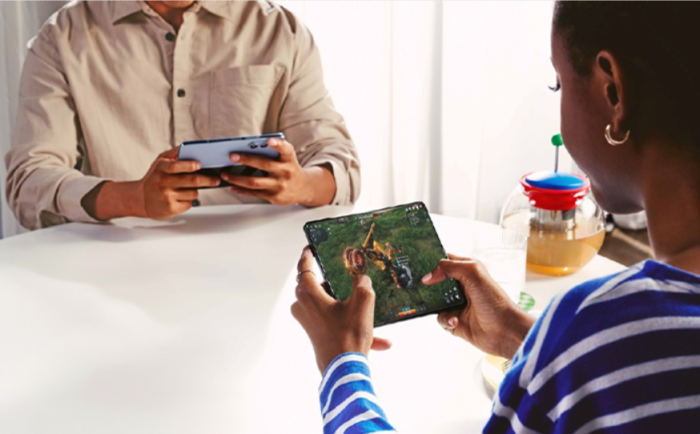 A　Samsung　Galaxy　Z　Fold　5　(right)　user　plays　a　mobile　game　(File　photo,　courtesy　of　Samsung　Electronics)