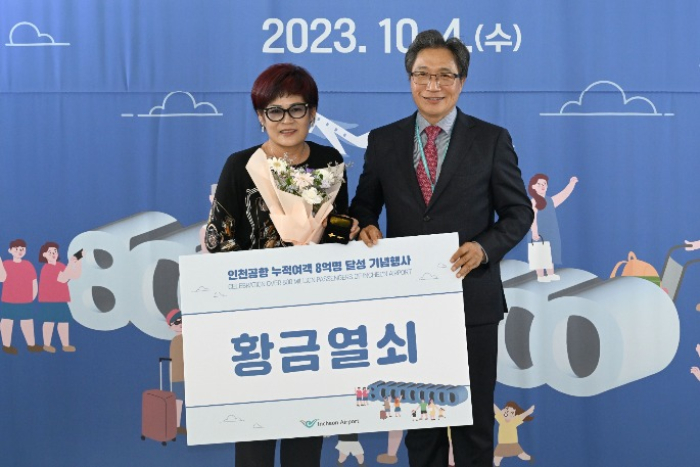 Lee　Hag-Jae,　President　and　CEO　of　Incheon　International　Airport　Corporation　(right)　gives　a　gold　key　to　800　millionth　passenger