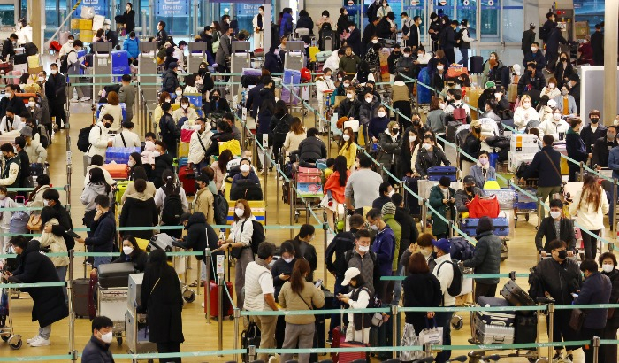 Travelers　line　up　to　board　planes　at　the　Incheon　International　Airport　terminal