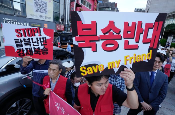 North　Korean　defectors　and　human-rights　activists　stage　a　rally　near　the　Chinese　Embassy　in　Seoul.　PHOTO:　AHN　YOUNG-JOON/ASSOCIATED　PRESS