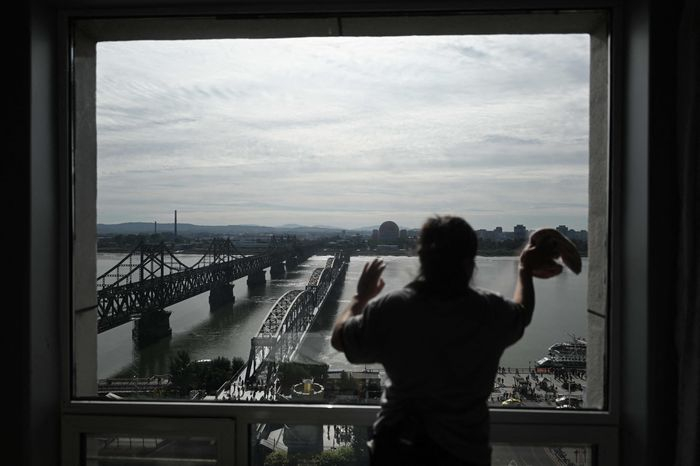 A　worker　cleans　a　hotel　window　in　the　Chinese　border　city　of　Dandong.　PHOTO:　PEDRO　PARDO/AGENCE　FRANCE-PRESSE/GETTY　IMAGES