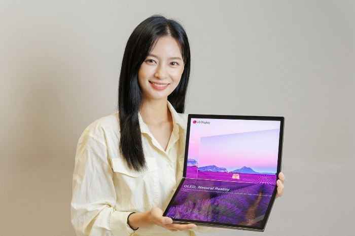 A　model　showcases　a　laptop　made　of　LG　Display's　7-inch　foldable　OLED　panel　(Courtesy　of　LG　Display)