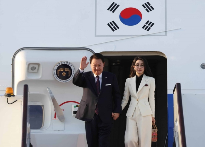 South　Korean　President　Yoon　Suk　Yeol　(left)　and　first　lady　Kim　Keon　Hee　arrive　at　Hamad　International　Airport　in　Doha　for　a　state　visit　to　Qatar　on　Oct.　24,　2023　(Photo　by　Bum-June　Kim)