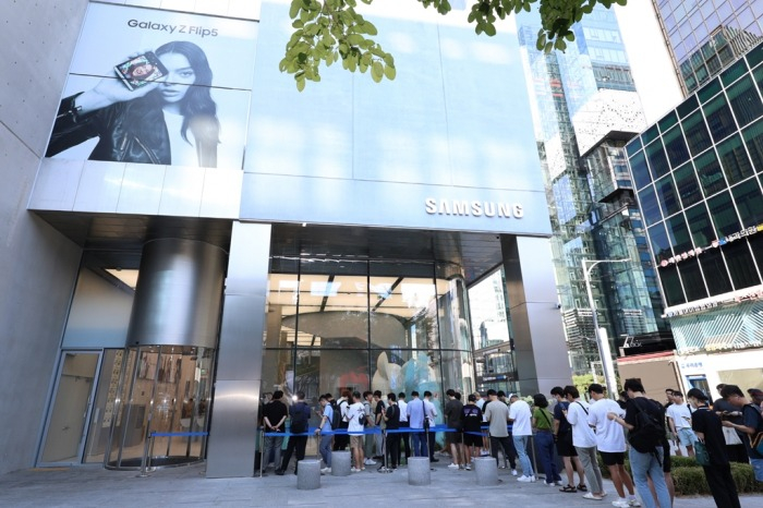 Shoppers looking to buy the latest Galaxy Z Fold5 and Flip5 smartphones queue in front of a Samsung sales outlet in Seoul