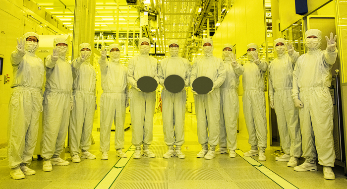 Samsung employees hold semiconductor wafers made with 3-nanometer technology