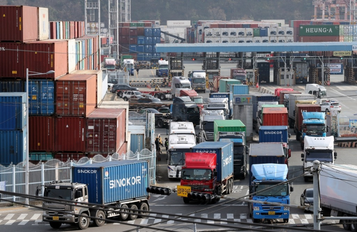 Container trucks are moving cargoes at Port of Busan (File photo, courtesy of Yonhap)