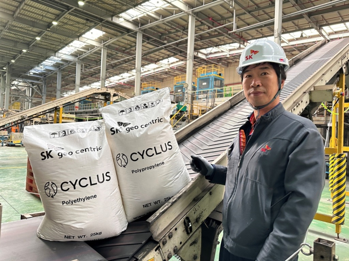 An SK Geo Centric employee displays products packed in sacks made with recycled materials at its parent SK Innovation’s chemicals factory in Ulsan, South Korea (Courtesy of SK Innovation)