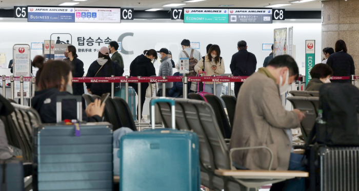 A　line　of　passengers　to　check　in　for　Japan-bound　flights　at　Gimpo　Airport