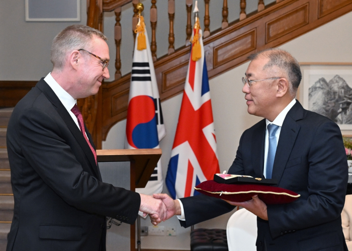 Hyundai　Motor　Chairman　Chung　Euisun　(right)　shakes　hands　with　British　Amb.　Colin　Crooks　after　he　was　awarded　the　CBE　medal　from　King　Charles　III