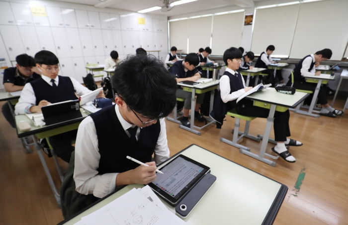 Students in a Korean high school classroom study using tablets and other devices