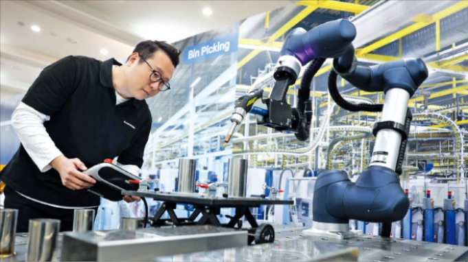 A　Doosan　Robotics　employee　inspects　a　collaborative　robot　at　its　factory　in　Suwon,　Gyeonggi　Province　(Courtesy　of　Doosan　Robotics)