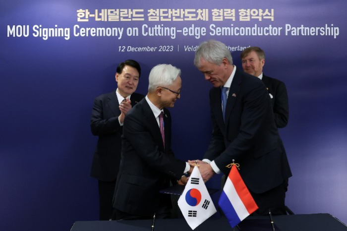 Samsung　CEO　Kyung　Kye-hyun　(on　left)　and　ASML　CEO　Peter　Wennink　shake　hands　at　ASML's　headquarters　in　Veldhoven　on　Dec.　12,　2023　after　signing　an　MOU　to　build　a　joint　research　plant　in　South　Korea　(Courtesy　of　News1　Korea)