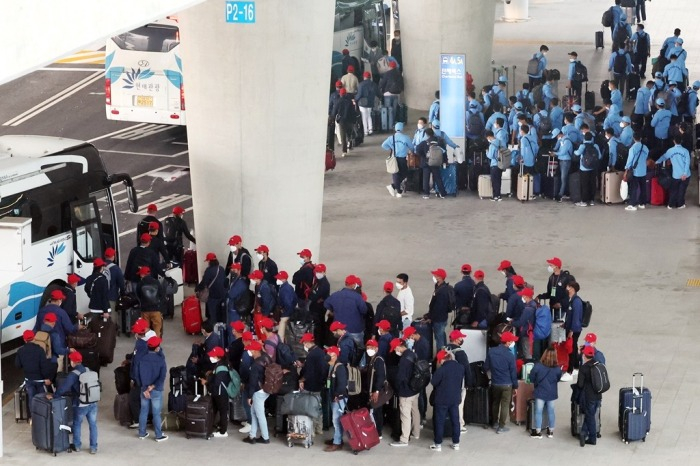 Foreign workers line up for the bus at Incheon International Airport