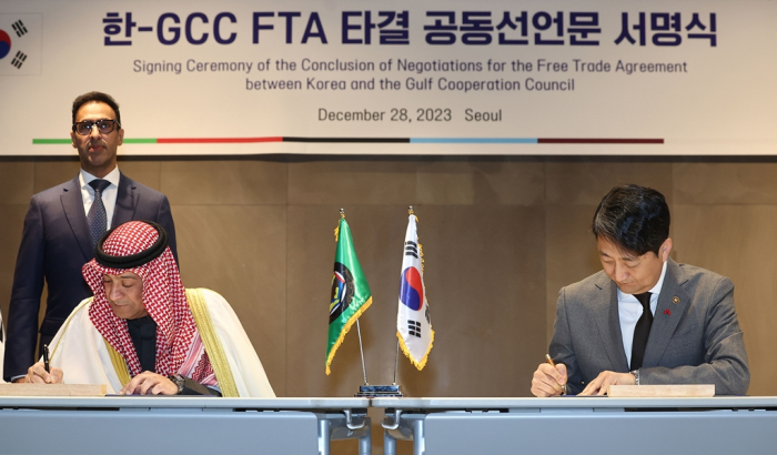 GCC　Secretary　General　Jassim　Muhammad　Al-Budaiwi　(left)　and　Korea’s　Trade　Minister　Ahn　Duk-geun　sign　a　free　trade　deal　in　Seoul