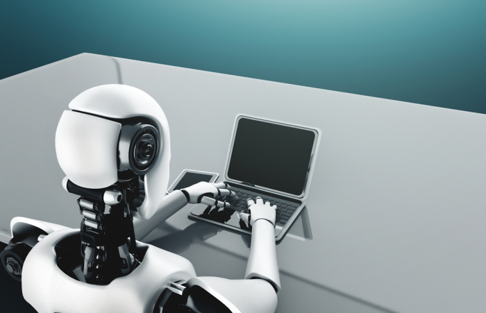 A robot humanoid backed by an AI-thinking brain uses a laptop (Courtesy of Getty Images)