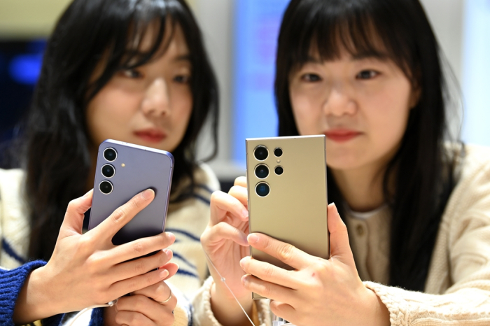 Customers take a look at their preordered Galaxy S24 smartphones at a Seoul showroom