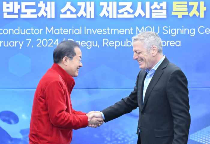 Daegu Mayor Hong Joon-pyo (left) shakes hands with Ilan Geri, president of IMC Group, after the Berkshire Hathaway-owned company agreed to invest million in the city