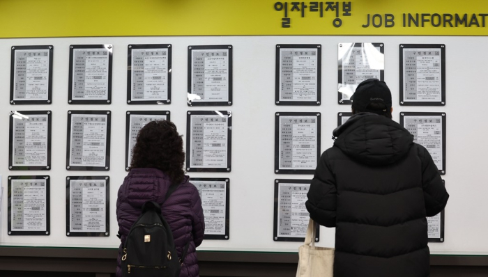 People　look　at　job　ads　at　an　employment　information　center　in　Seoul　on　Feb.　16,　2024　(Courtesy　of　Yonhap)