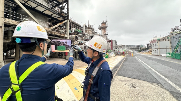 SK　Energy　employees　check　a　smart　scaffolding　system　at　a　construction　site