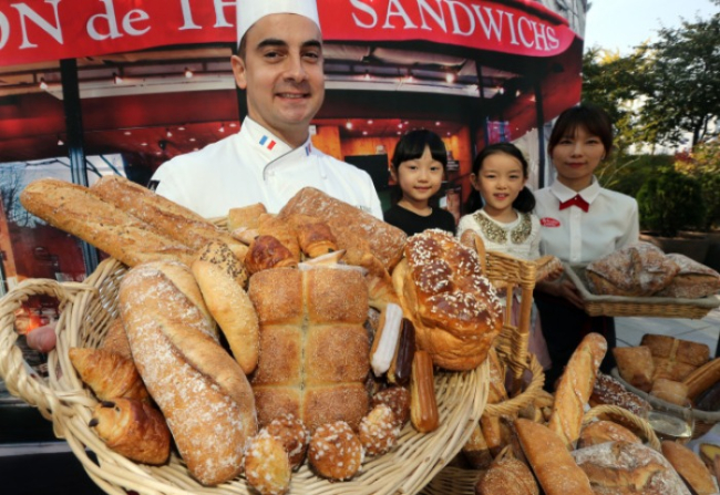 Brioche Dorée baker displays a basket of bread at its first Korean store in 2013