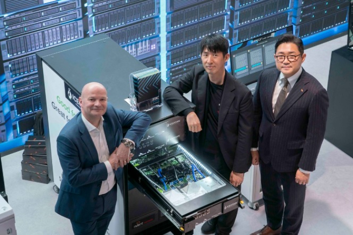 David　Craig,　Iceotope　CEO　(on　left),　Lee　Jong-min,　vice　president　and　head　of　Future　R&D　at　SK　Telecom,　and　Seo　Sang-hyuk,　head　of　e-Fluids　B2B　Business　Management　Office　at　SK　Enmove　pose　for　a　photo　next　to　a　server　using　liquid　immersion　cooling　technology　set　up　in　the　SK　Telecom　exhibition　hall.　(Courtesy　of　SK　Telecom)
