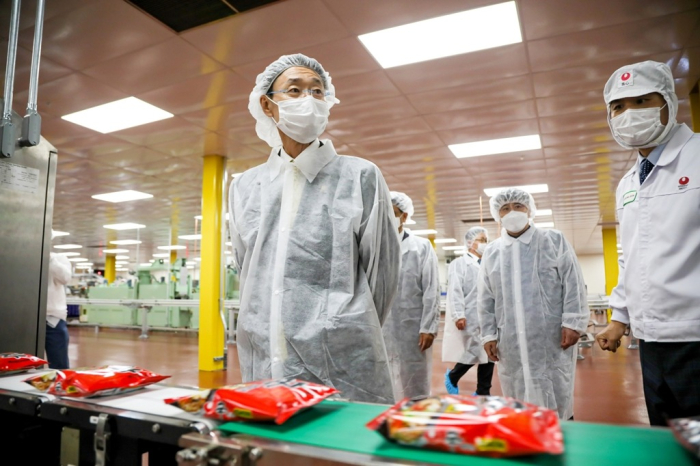 Nongshim　Chairman　and　Chief　Executive　Shin　Dong-won　(center)　at　the　company’s　No.　2　US　plant　(File　photo,　Nongshim)