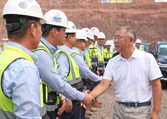 Hyundai　Motor　Chairman　Chung　Euisun　shakes　hands　with　Hyundai　E&C　workers　on　a　construction　site　at　Saudia　Arabia's　Neom　City　in　October　2023
