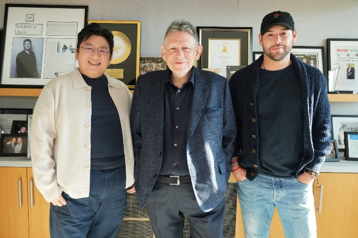 HYBE Chairman Bang Si-Hyuk (on left), Sir Lucian Grainge, chairman and CEO of Universal Music Group, and Scooter Braun, CEO of HYBE America, pose for a photo after the long-term exclusive music distribution deal (Courtesy of HYBE)