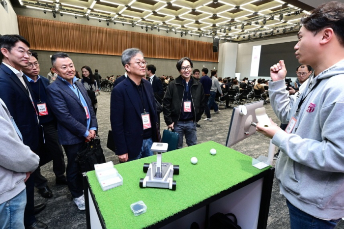 LG Electronics CSO Kim Sam-soo (center) listens as X-UP, an in-house venture firm, presents a new product at LG Science Park