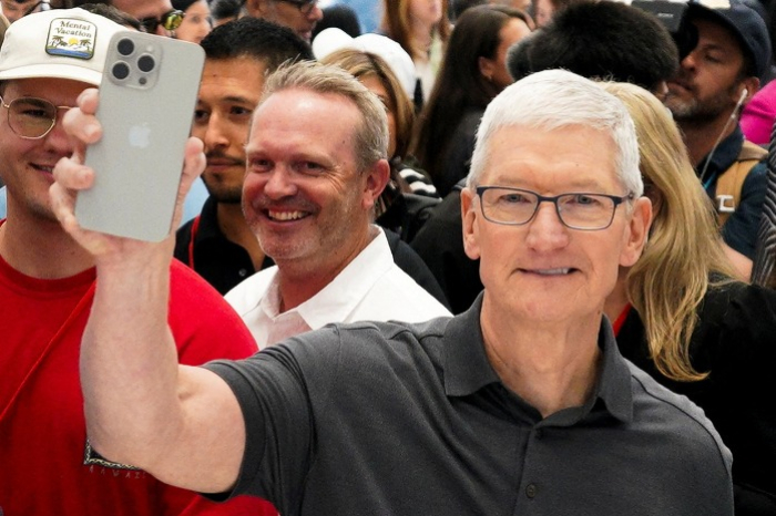 Apple　CEO　Tim　Cook　holds　the　latest　iPhone　15　series 
