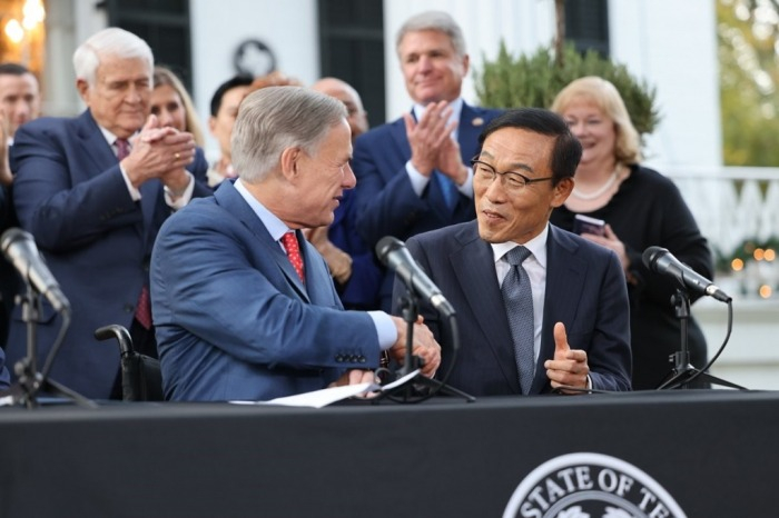 In　November　2021,　Texas　Governor　Greg　Abbott　(left)　and　Kim　Ki-nam,　then-vice　chairman　of　Samsung　Electronics,　announce　a　　billion　plant　deal