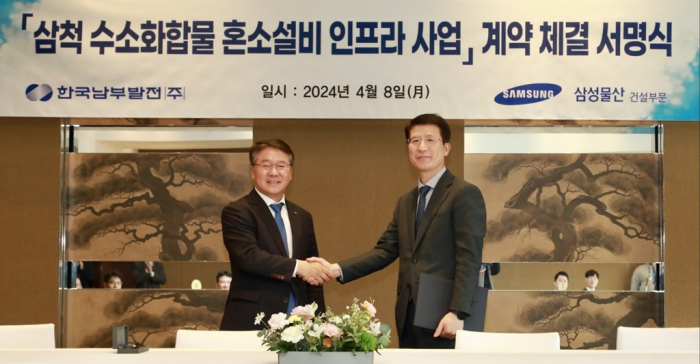 KOSPO CEO Lee Seung-woo (left) shakes hands with Samsung C&T's construction unit CEO Oh Se-chul after signing a deal for Samsung to build a hydrogen tank at a KOSPO plant