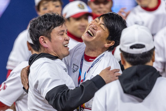 Shinsegae Group Chair Chung Yong-jin (left) embraces SSG Landers pitcher Kim Kwang-hyun