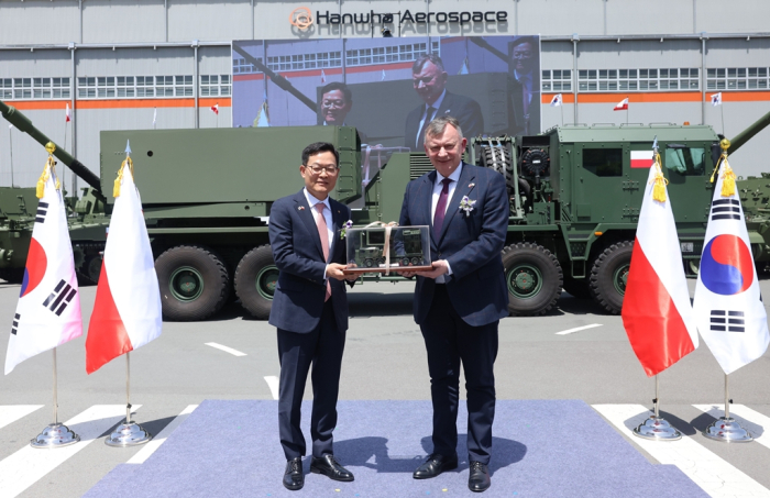 Hanwha Aerospace CEO Son Jae-il (left) and Artur Kuptel, head of the Polish State Armament Agency, sign a />.6 billion Chunmoo rocket launcher deal on April 25, 2024