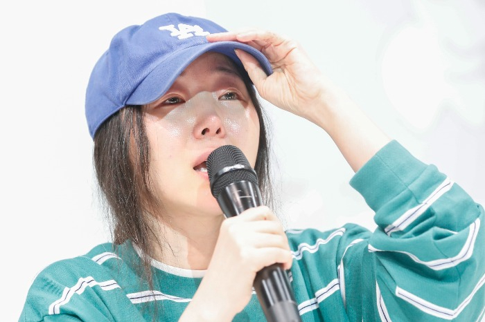 Min Hee-jin speaks to reporters in tears at a news conference