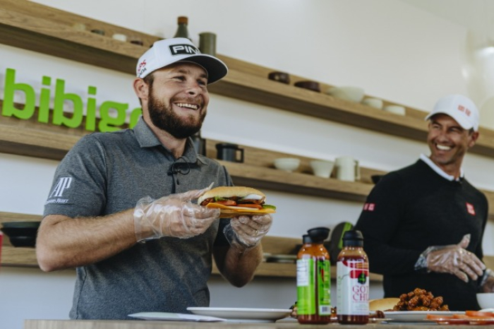 Golfers　Tyrrell　Hatton　(left)　and　Adam　Scott　taste　Bibigo　food　during　the　CJ　Cup　PGA　tour　in　2021　(Courtesy　of　CJ　Cheiljedang)
