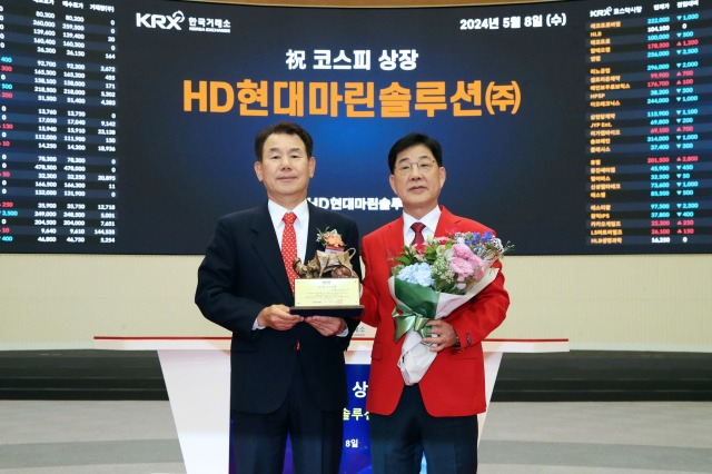 Korea Exchange CEO Jeong Eun-bo (left) and HD Hyundai Marine Solution CEO Lee Ki-dong celebrate HD Hyundai Marine's Kosdaq debut on May 8 (Courtesy of KRX)