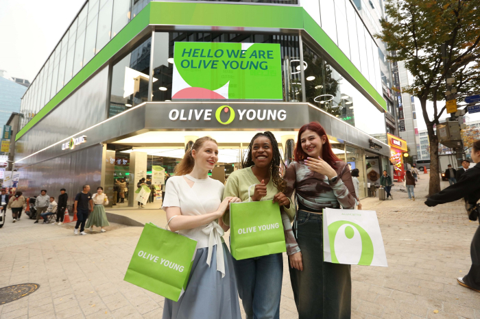 Foreign　shoppers　leave　the　CJ　Olive　Young　store　in　Myeong-dong,　Seoul　with　their　purchases